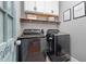 Well-organized laundry room has modern appliances and stylish overhead cabinets with floating wood shelves at 175 Brazil Nut Ln, Smithfield, NC 27577