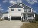 Two-story home featuring a two-car garage, porch, gray siding, and dark shutters set against a bright blue sky at 176 Golfview Ave, Benson, NC 27504