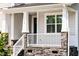Inviting front porch with stone accents, white railings, and pillars, offering a cozy outdoor space at 176 Golfview Ave, Benson, NC 27504