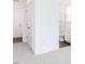 Hallway leading to a bathroom, featuring neutral carpet, white walls, and a linen closet at 176 Golfview Ave, Benson, NC 27504
