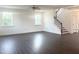 Open-concept living room with lots of natural light, dark wood floors, and a staircase leading upstairs at 176 Golfview Ave, Benson, NC 27504