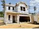New two-story home showing exterior construction with attached two car garage and building wrap at 180 Muskogee Rd # 53, Angier, NC 27501