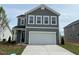 Charming two-story home with gray siding and a spacious two-car garage, nestled in a well-manicured lawn at 183 Little Crk Dr, Lillington, NC 27546