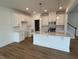 Modern, bright kitchen featuring white cabinets, stainless steel appliances, large island with pendant lighting at 183 Little Crk Dr, Lillington, NC 27546
