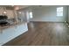 Open-concept living room featuring hardwood floors with a large window providing natural light, seamlessly flowing from the kitchen at 183 Little Crk Dr, Lillington, NC 27546
