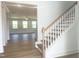 Elegant foyer with hardwood flooring, a staircase, and a view into a sunlit living area at 196 Golfview Ave, Benson, NC 27504