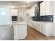 Modern kitchen featuring white cabinetry, quartz countertops, stainless steel appliances, and hardwood flooring at 196 Golfview Ave, Benson, NC 27504