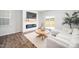 Cozy living room featuring a fireplace, wood flooring, and a modern sectional sofa at 196 River Bank Rd, Fuquay Varina, NC 27526