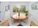 Bright dining room with wood table, stylish chairs, and a large window providing natural light and views of the outdoors at 2 Banbury Ln # 2, Chapel Hill, NC 27517