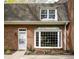 Charming brick home featuring a bay window and a white front door with beautiful landscaping at 2 Banbury Ln # 2, Chapel Hill, NC 27517