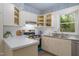 Functional kitchen with stainless steel appliances, white cabinets, and a bright window overlooking greenery at 2 Banbury Ln # 2, Chapel Hill, NC 27517
