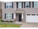 Close-up of the home's inviting front entry with a black front door and stone accents at 211 Richmond Run, Stem, NC 27581