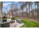 A serene patio with comfortable outdoor seating overlooks a lush, grassy yard and wooded area at 211 Richmond Run, Stem, NC 27581