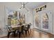 Bright dining area with a rustic wooden table and chairs, featuring a modern light fixture and access to the outdoors at 2207 Otis St # A, Durham, NC 27707