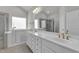 Bright bathroom features a walk-in tub, double vanity with white counters, and separate shower at 233 Stone River Dr, Wendell, NC 27591