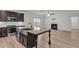 Well-equipped kitchen with island, stainless appliances, granite counters, and open view to the living room fireplace at 233 Stone River Dr, Wendell, NC 27591