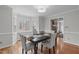 Elegant dining room featuring a dark wood table, neutral chairs, and bright natural light at 2629 Sweetgum Dr, Apex, NC 27539