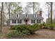 Traditional home with symmetrical facade, dormer windows, red door, and mature shrubbery at 2629 Sweetgum Dr, Apex, NC 27539
