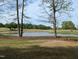 Scenic view of the golf course and pond, framed by trees and a blue sky backdrop at 2629 Sweetgum Dr, Apex, NC 27539