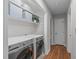Modern laundry room with front-load washer/dryer, white shelving, and storage baskets at 2629 Sweetgum Dr, Apex, NC 27539