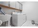 Well-lit laundry room features modern appliances and ample cabinet space at 270 Trailing Bluff Way, Garner, NC 27529
