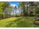 Expansive backyard with lush lawn, mature trees, and a storage shed for outdoor equipment at 2832 Steeple Run Dr, Wake Forest, NC 27587