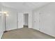 A bedroom with neutral walls and carpet, featuring white doors and trim, plus a modern floor lamp at 2832 Steeple Run Dr, Wake Forest, NC 27587