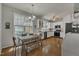 Eat-in kitchen featuring white cabinets, stainless steel appliances, hardwood floors, and a wooden dining table at 2832 Steeple Run Dr, Wake Forest, NC 27587