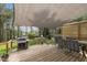A covered outdoor deck, with outdoor dining furniture and a BBQ grill at 2832 Steeple Run Dr, Wake Forest, NC 27587