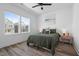 Bright bedroom with a large window, ceiling fan and bed with olive green bedding, and minimalist decor at 304 Rivella Dr, Wake Forest, NC 27587