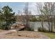 Charming lakefront with a wooden dock, gazebo, and seating area, surrounded by lush trees and landscaping at 304 Rivella Dr, Wake Forest, NC 27587