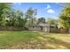 Spacious, fenced backyard featuring a well-maintained lawn, mature trees, and a patio area at 3332 Apache Dr, Raleigh, NC 27609