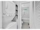 Bathroom has a washer and dryer in a closet next to a shower and tub with white tile at 3332 Apache Dr, Raleigh, NC 27609