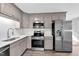 Updated kitchen featuring stainless steel appliances, gray cabinets, and subway tile backsplash at 3332 Apache Dr, Raleigh, NC 27609