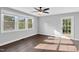 Bright living room featuring hardwood floors, a ceiling fan, and large windows to let sunlight into the space at 3332 Apache Dr, Raleigh, NC 27609