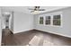 Bright living room features hardwood floors, a ceiling fan, and large windows to let sunlight into the space at 3332 Apache Dr, Raleigh, NC 27609