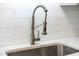 Close-up of the stainless-steel sink with a modern, pull-down faucet and white countertops at 3332 Apache Dr, Raleigh, NC 27609