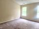 Bright bedroom with neutral walls, plush carpeting, and a large window bringing in natural light at 4616 Silverdene St, Raleigh, NC 27616