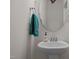 Bright bathroom featuring pedestal sink, round mirror, and a soft, blue towel at 486 Autumn Rain St, Cary, NC 27519