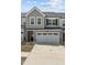 Beautifully designed townhome with two-car garage, stone accents, and grey vertical siding at 486 Autumn Rain St, Cary, NC 27519