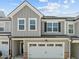 Beautifully designed townhome with two-car garage, stone accents, and grey vertical siding at 486 Autumn Rain St, Cary, NC 27519