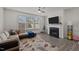 Bright living room features fireplace, ceiling fan, hardwood floors, and a large window at 486 Autumn Rain St, Cary, NC 27519