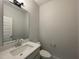 Modern half-bathroom featuring a stylish mirror, vanity with quartz countertop, and neutral wall colors at 486 Traditions Grande Blvd # 28, Wake Forest, NC 27587