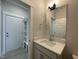 Modern bathroom features a sink with a quartz countertop, a stylish mirror, and access to the mud room at 486 Traditions Grande Blvd # 28, Wake Forest, NC 27587