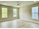 Spacious bedroom featuring three large windows offering abundant natural light and new vinyl plank flooring at 486 Traditions Grande Blvd # 28, Wake Forest, NC 27587