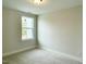 Cozy bedroom with a neutral color scheme, carpet flooring, and a window providing natural light at 486 Traditions Grande Blvd # 28, Wake Forest, NC 27587