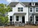 Charming two-story home with white siding, black trim, and a small front yard behind a black metal fence at 486 Traditions Grande Blvd # 28, Wake Forest, NC 27587