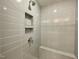 Modern tiled shower with built in shower caddy and a shower bench at 486 Traditions Grande Blvd # 28, Wake Forest, NC 27587
