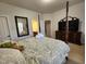 Inviting bedroom featuring a four-poster bed, a dresser with a TV, and a decorative mirror at 502 Willowmere Ct, Cary, NC 27513