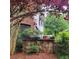 Exterior view of a home with a stone retaining wall, lush plantings, and a red tree at 502 Willowmere Ct, Cary, NC 27513
